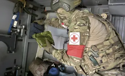 Военный медик оказывает помощь бойцу в полевых условиях на СВО — госпиталь, эвакуация раненых, современное оснащение и высокий уровень подготовки.