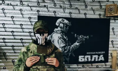 Оператор БПЛА на СВО за рабочим пультом во время управления дроном в тыловой зоне